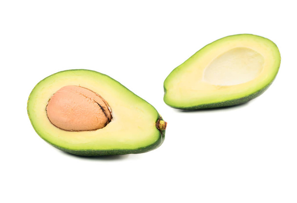 Green avocado cut into two halves on white background - Foto, Bild