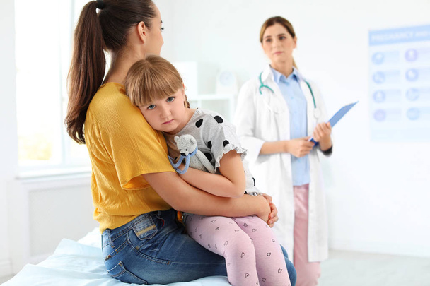 Κοριτσάκι με γονέα που επισκέπτονται το γιατρό του παιδιού στο νοσοκομείο - Φωτογραφία, εικόνα