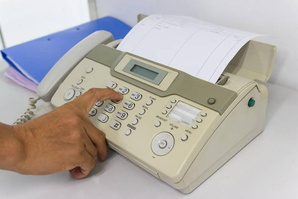 Άνθρωπος χέρι χρησιμοποιείτε ένα χαρτί μηχάνημα με αποστολή fax με το γραφείο της επιχειρηματικής ιδέας  - Φωτογραφία, εικόνα