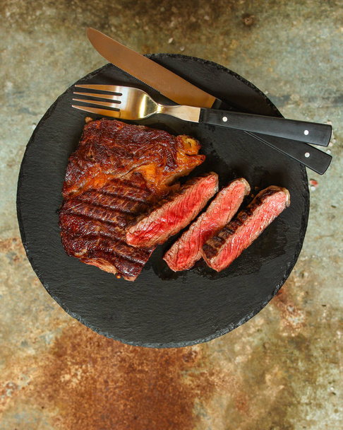 biefstuk gegrilde met kruiden (stuk vlees). Bovenaanzicht met kopie ruimte - Foto, afbeelding