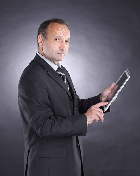 modern businessman with a digital tablet.isolated on black background - Фото, изображение