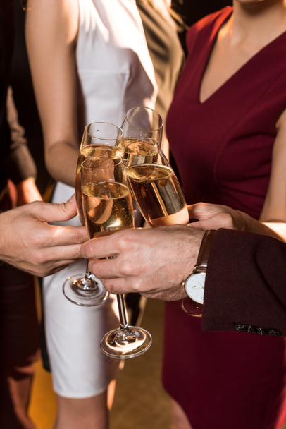 cropped shot of friends clinking champagne glasses during holiday party - Photo, Image