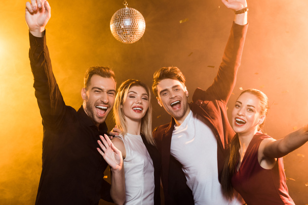 group of friends looking at camera and celebrating during holiday party - Photo, image