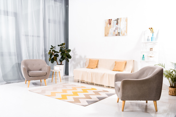 interior de la moderna sala de estar con alfombra, sofá y pintura en la pared
  - Foto, Imagen