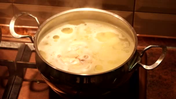 Chicken broth is cooked in a saucepan on the stove - Footage, Video