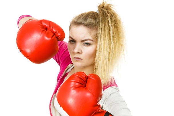 Спортивная женщина в красных боксерских перчатках, дерётся. Студия на белом фоне. - Фото, изображение