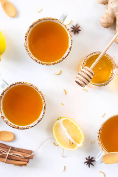Τσάι με κουρκούμη μεταξύ των προϊόντων για τη βελτίωση της ασυλίας και τη θεραπεία κρυολογήματα - λεμόνι, μέλι, τζίντζερ, γλυκάνισο. Το Top view, επίπεδη lay - Φωτογραφία, εικόνα