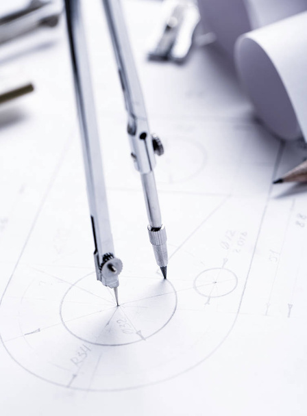 Learn to draw circles with a compass. Compasses and Architect scale ruler placed on the desk, filled with building plans. selective focus - Photo, Image