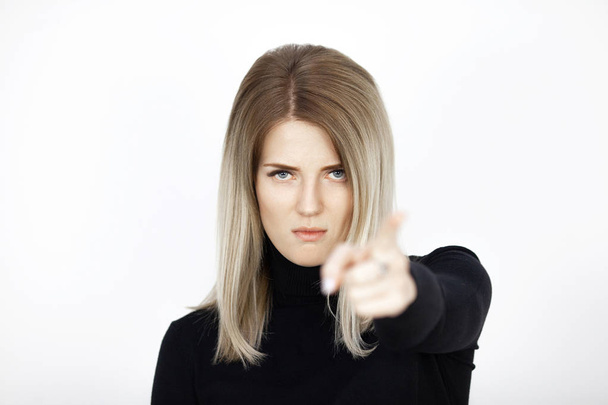 Young attractive blonde woman shows finger into camera with conviction. Emotion portrait - Foto, imagen