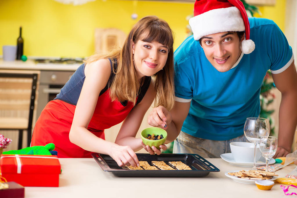 Young couple celebrating Christmas in kitchen  - Photo, Image