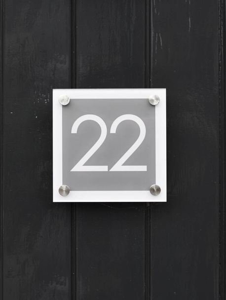 Talo numero 22 puinen seinä onnellinen uusi koti siirtymässä pois moderni ovi numero kaksikymmentäkaksi
  - Valokuva, kuva