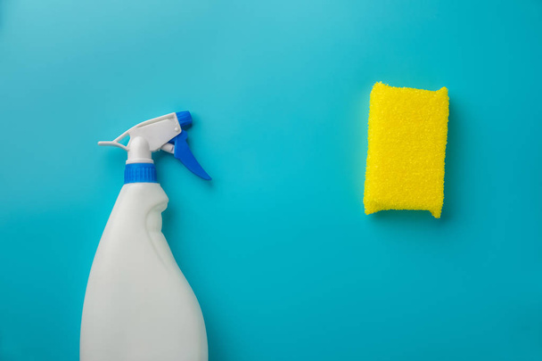 cleaning agent in a white bottle with a sponge on a blue background - Fotoğraf, Görsel