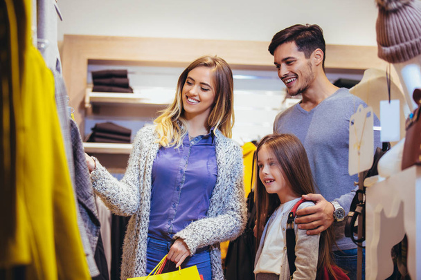 Family shopping for clothes and looking happy - Fotoğraf, Görsel