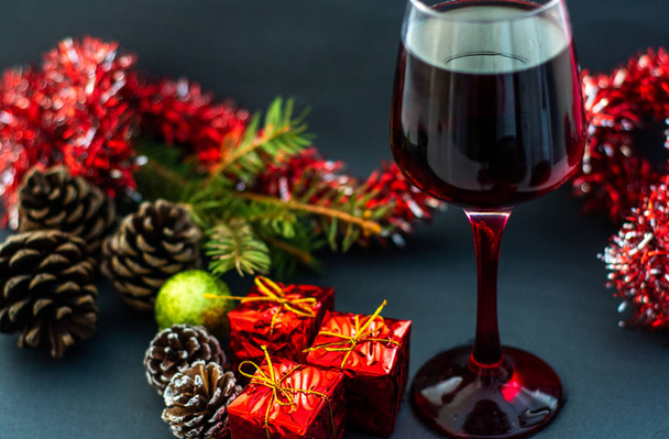 Χριστουγεννιάτικα Ενοικιαζόμενα κόκκινο κρασί στο τραπέζι από ξύλο και το χριστουγεννιάτικο δέντρο - Φωτογραφία, εικόνα