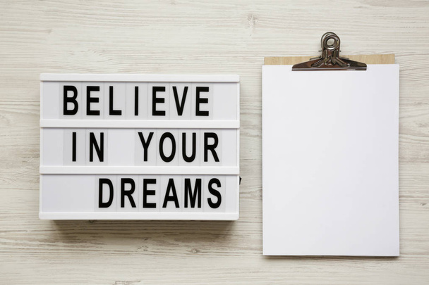 'Believe in your dreams' word on modern board, noticeboard over white wooden background, top view. Flat lay, from above, overhead. - Photo, Image