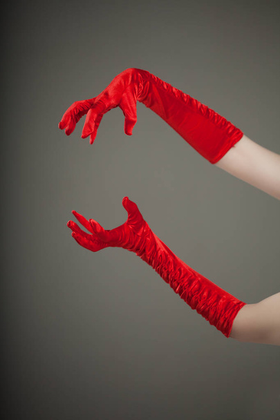 Elegant empty open female hands in red silk or satin gloves, free space presenting your product or text - Photo, image