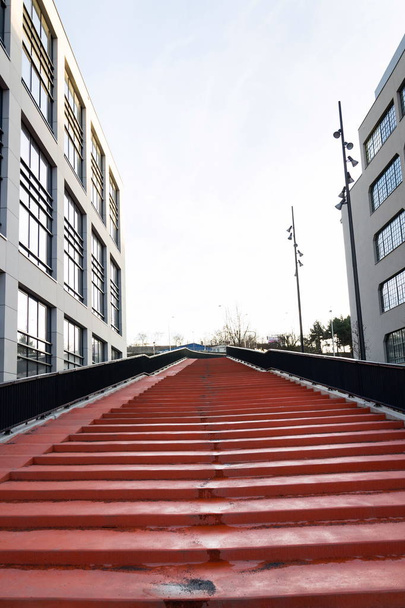 Escaliers rouges menant au ciel entre les immeubles de bureaux modernes, le coworking et le concept d'espace de travail
 - Photo, image