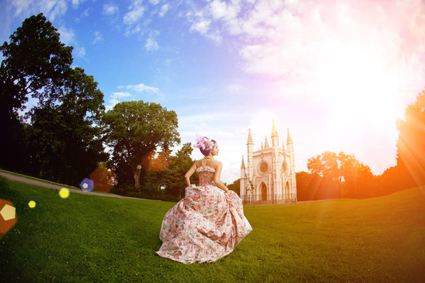 A woman like a princess in an vintage dress before the magic castle - Фото, зображення