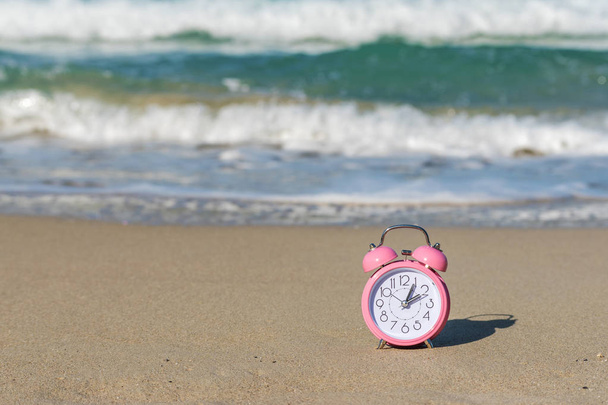 Alarm clock on the beach. Summer vacation concept. - Фото, изображение