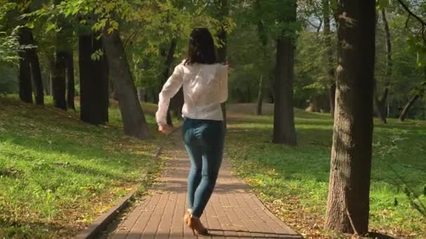 SHooting From BEhind, Beautiful Brunette Caucasian Female Is Dancing in Latin Style On Pathway In Green Park In Spring Warm Time, Pure Nature, Motions - Footage, Video