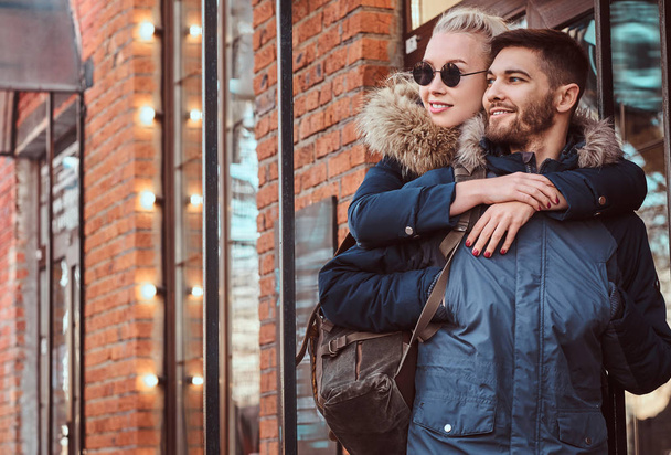 Egy boldog vonzó pár visel téli kabátok kiadási időt együtt szabadban. - Fotó, kép