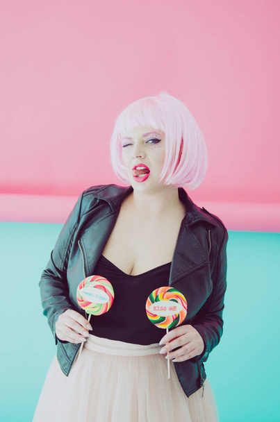 Beautiful young sensual woman with pink hair posing with lollypops - Фото, зображення