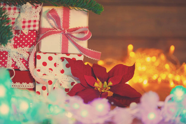 クリスマス カード。新年のパーティーのテーマの背景。ギフトやお祝いのカラフルなライトの背景にキャンドルでモミの木が飾られています。魔法の夜. - 写真・画像