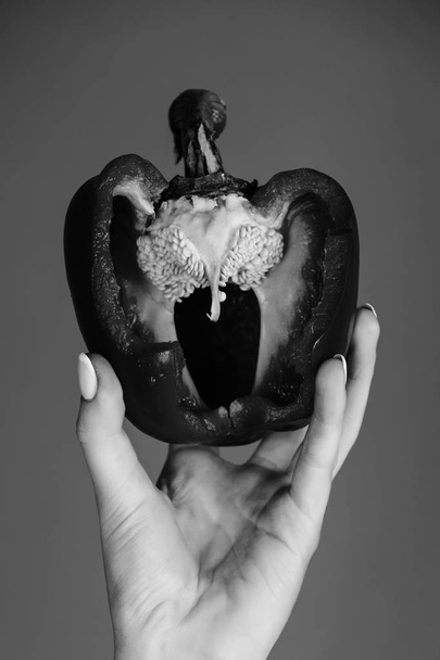il peperone in mano di donna tiene la paprica dolce, il cuore
 - Foto, immagini