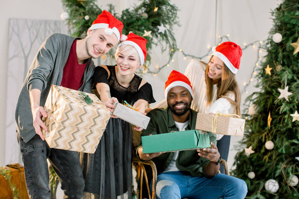 Happy three Caucasian boy and girls and African boy smiling and having fun on Christmas celebration. - Photo, image