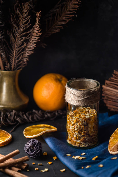 Cosy winter holiday background with orange zest peel spicy ingredients baking. Christmas still life with dried orange slices and cinnamon - Fotografie, Obrázek