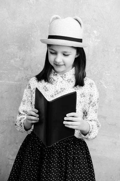 Cute girl reading black note book - Fotó, kép