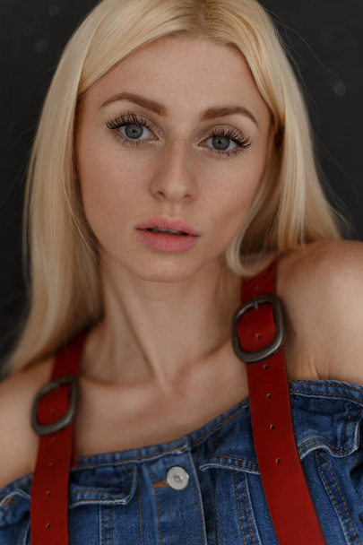 Fresh portrait of a pretty young attractive woman with freckles in denim clothes on a black background. - Zdjęcie, obraz