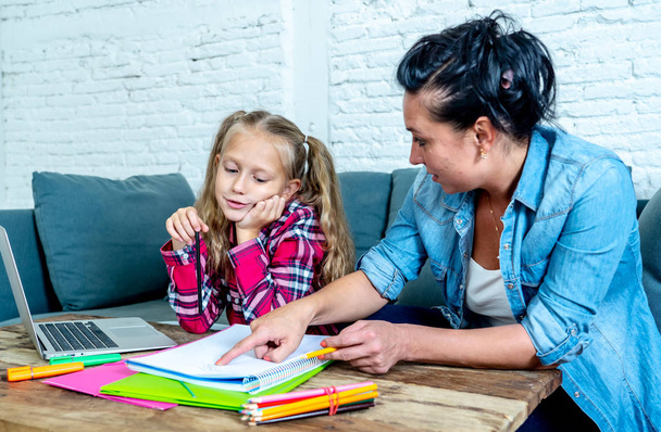 Mother becoming frustrated with daughter whilst doing homework sitting on sofa At home in learning difficulties homework parenting and education concept - Photo, image