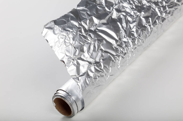 Rouleau de papier d'aluminium sur fond blanc, gros plan
. - Photo, image