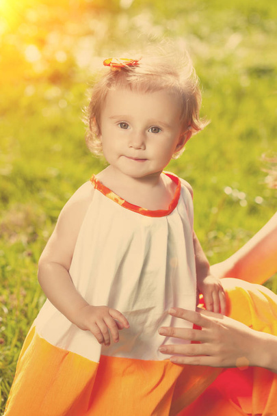 Cute little baby girl on grass in nature outdoors - Foto, imagen