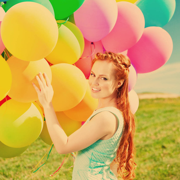 Luxury fashion stylish woman with balloons in hand on the field against the sky and - Φωτογραφία, εικόνα