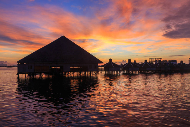 mooie twilight zonsopgang met silhouet drijvend resort in Semporna, Sabah, Borneo (afbeelding bevatten bepaalde graan of lawaai en soft focus Sea....) - Foto, afbeelding