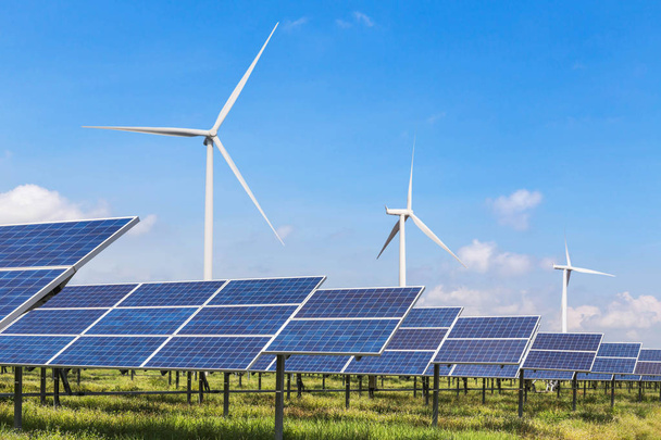 Wierszy tablicy polikrystalicznych krzemu panele słoneczne i turbiny wiatrowe wytwarzania energii elektrycznej w hybrydowych elektrowni systemów stacji  - Zdjęcie, obraz