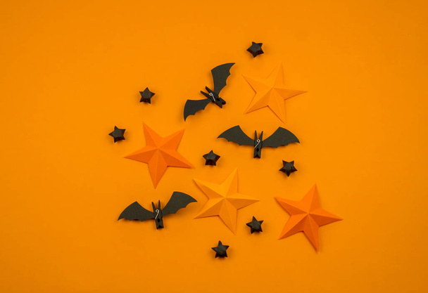 Orange background with collection of Halloween objects overhead view. Spider, bat, stars, holiday pattern. - Foto, Imagem
