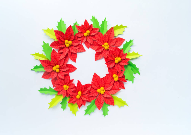 Paper flower poinsettia and leaves of holly. Christmas wreath. White background. Colors are green, red, yellow. - Foto, immagini