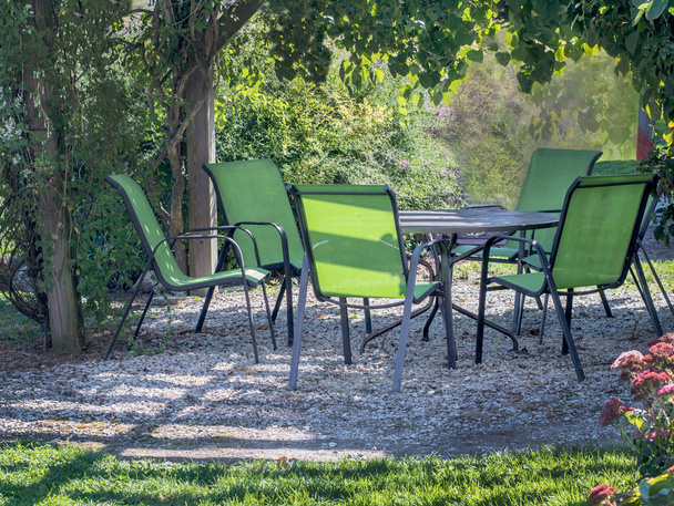 bonita mesa y sillas bajo un cenador de jardín verde, en un hermoso día de otoño
 - Foto, imagen