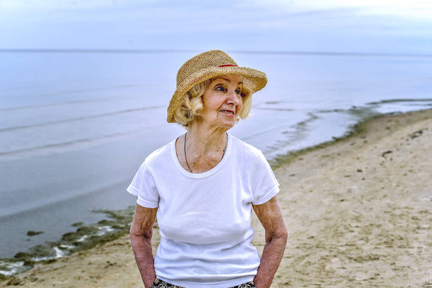 elderly woman walking near the sea - Photo, Image