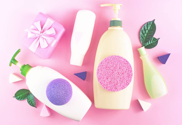 Kosmeettinen pakkaus muovipullo shampoo kerma suihku geeli maito vihreät lehdet sieni laatikko lahja keula. Luonnollinen orgaaninen tuote iho ja hiustenhoito ostoksia. Top näkymä vaaleanpunainen tasainen tausta. Valikoiva painopiste
 - Valokuva, kuva