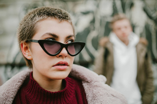 Girl with short hair in black sunglasses on the street - Photo, image