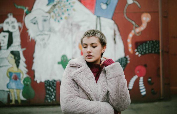 young girl with short hair and short coat on the street - Photo, Image