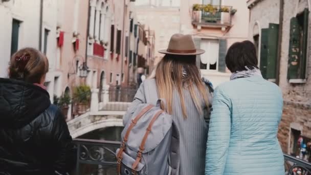 Back view young daughter and senior mother stand together on canal bridge enjoying the view on vacation in Venice Italy. - 映像、動画