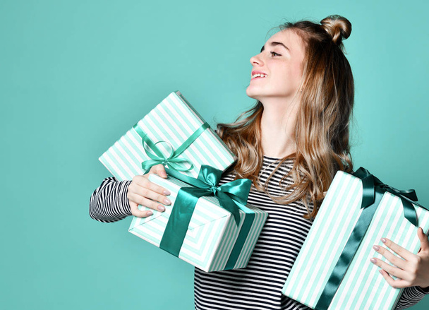 Portrait of a happy young woman hold blue present gift boxes looking at the corner - Foto, Imagen