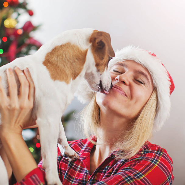Happy woman with dog in christmas decoration - Foto, imagen