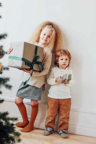 Pretty brother and sister stay with presents, Christmas time - Photo, Image