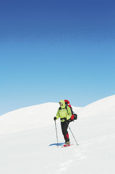 Winter hiking in the mountains with a backpack in snowshoes. - Foto, Bild